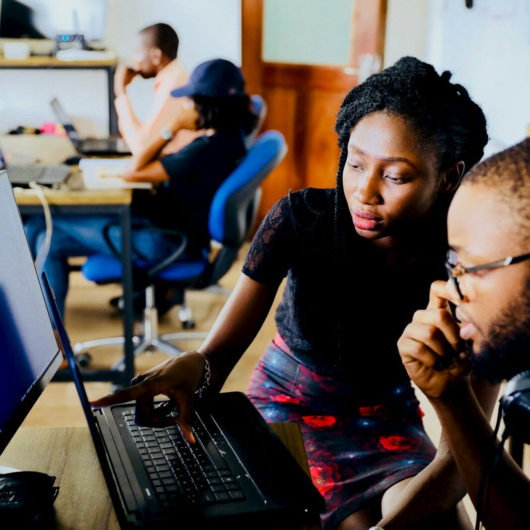 woman and man sitting in front of monitor